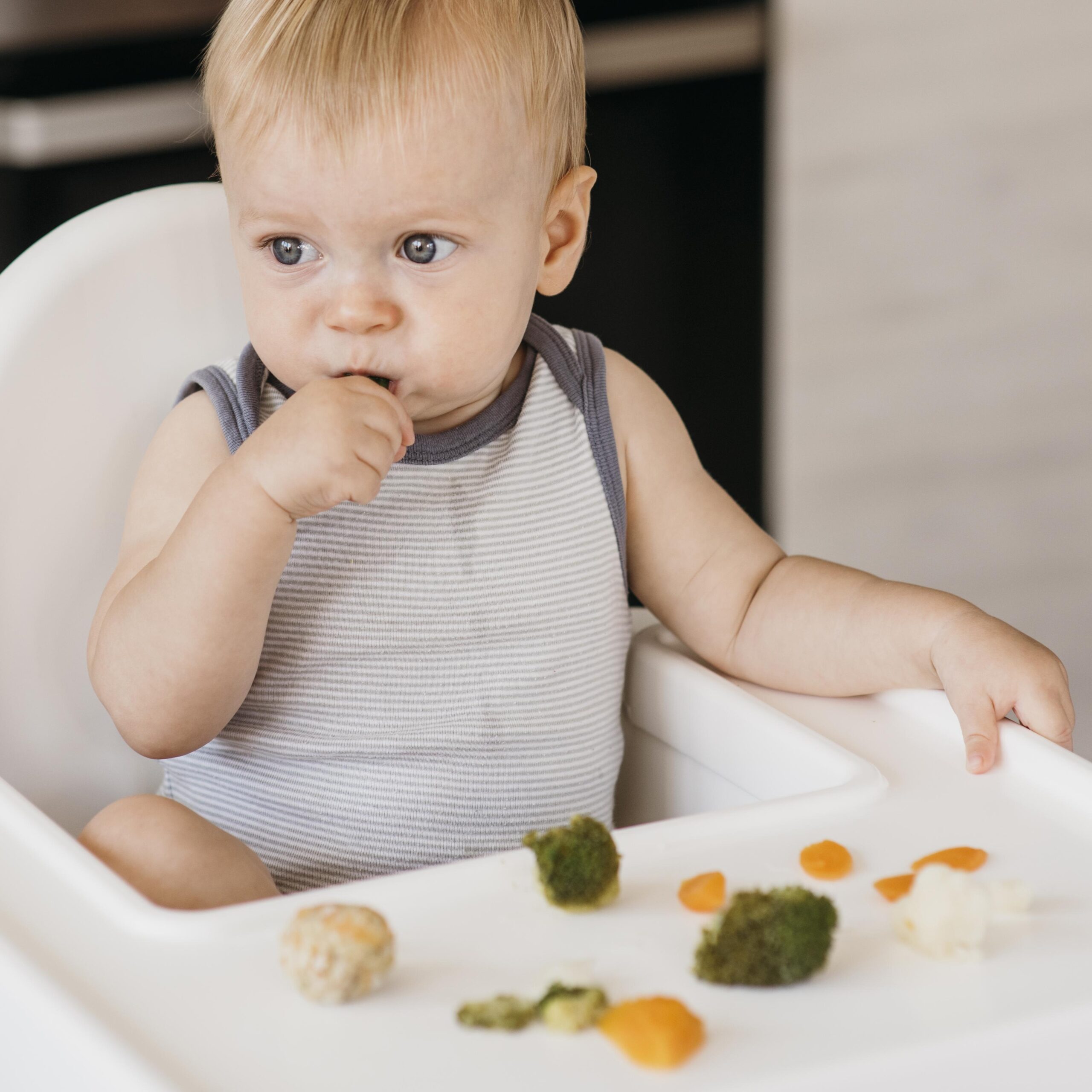 cute-baby-boy-highchair-eating-vegetables