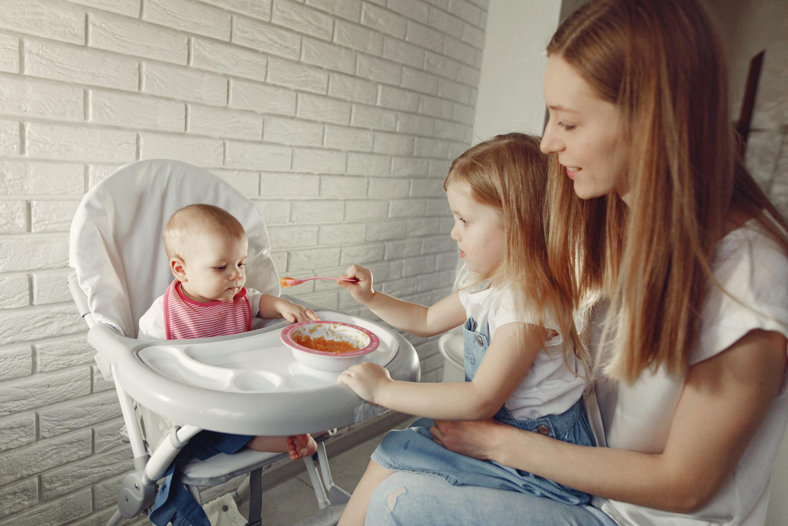 Mother feeds the little baby in a kitchen